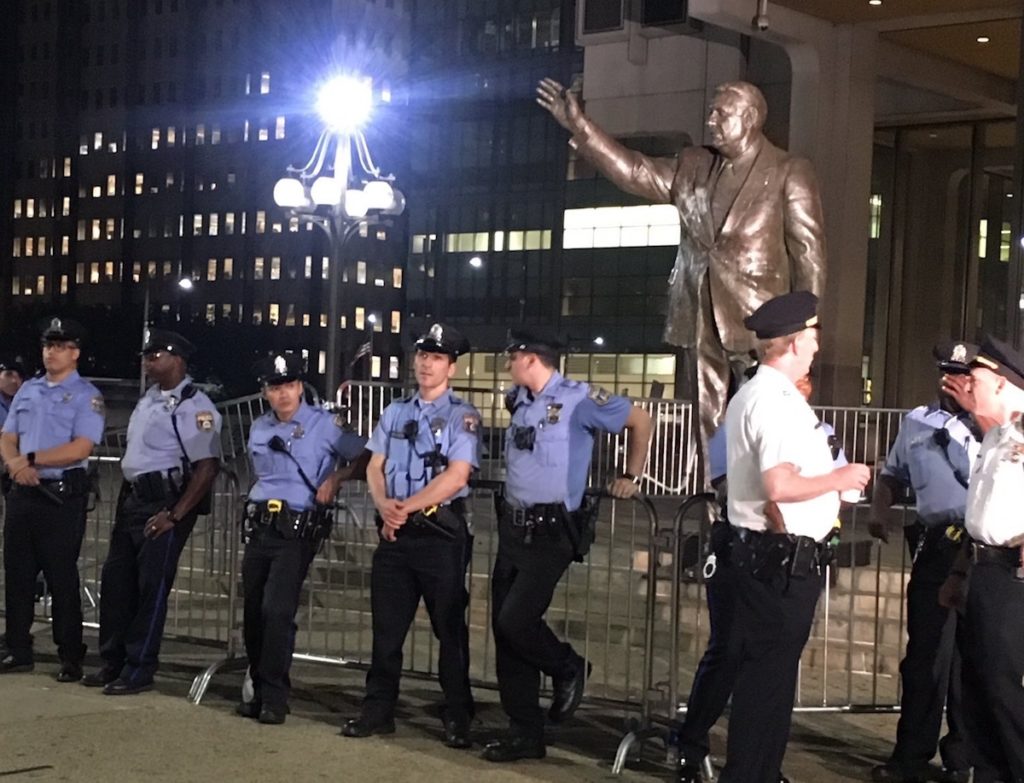 The Frank Rizzo statue, guarded by police officers after a night of protests.