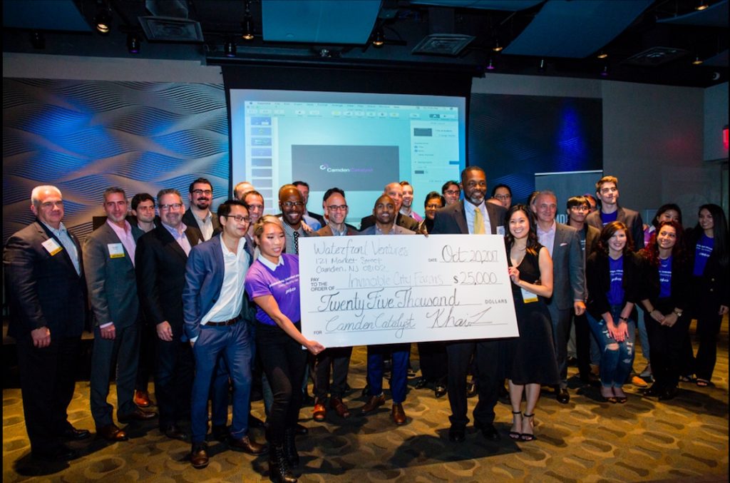 <em>Fredric Byarm receives a check for $25,000 with judges, sponsors and Khai Tran, CEO of Waterfront Ventures. (Courtesy photo)</em>